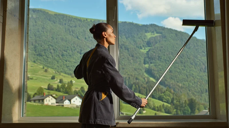 Fensterreinigung mit Abzieher auf einer grossen Glasfläche – illustrative Szene